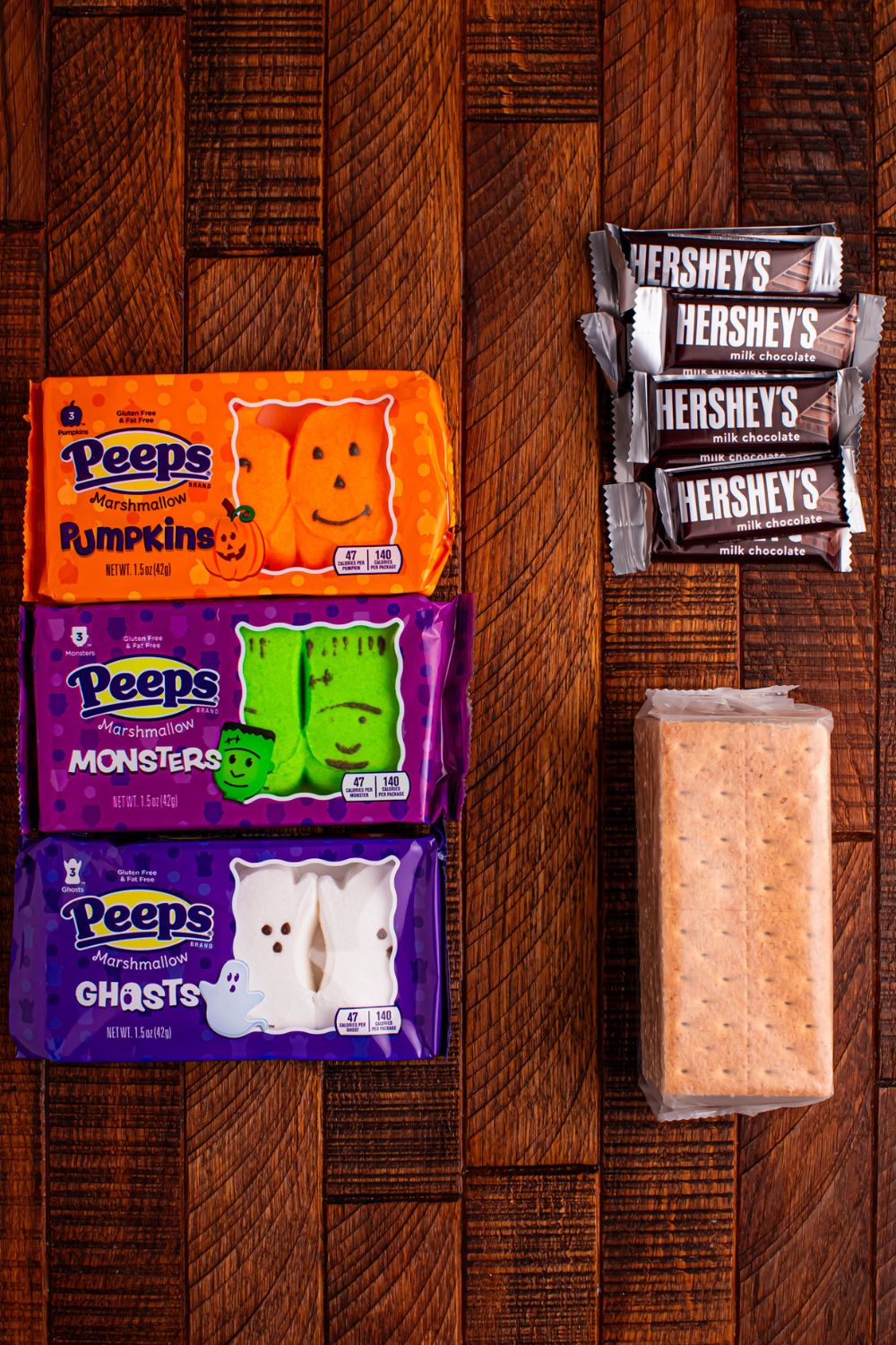 Halloween Smores Gift Bag ingredients on table: graham crackers, Hershey's, and Peep marshmallows