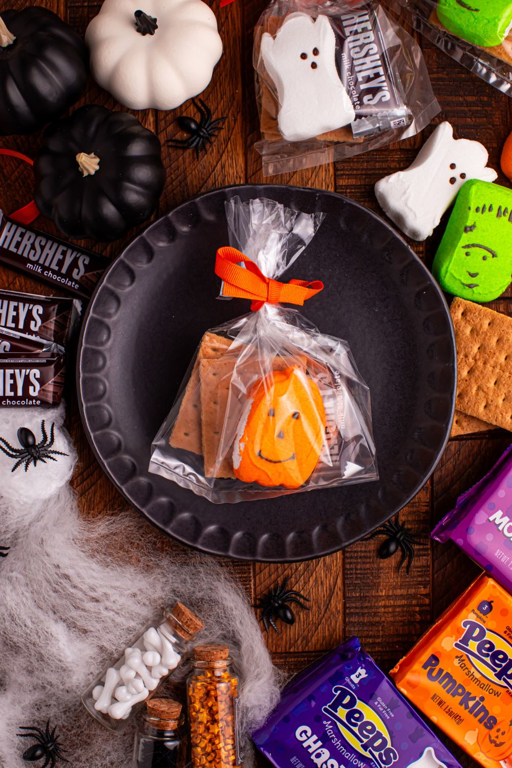 Halloween Smores Gift Bag on a plate on table with marshmallows and chocolate around it on table 
