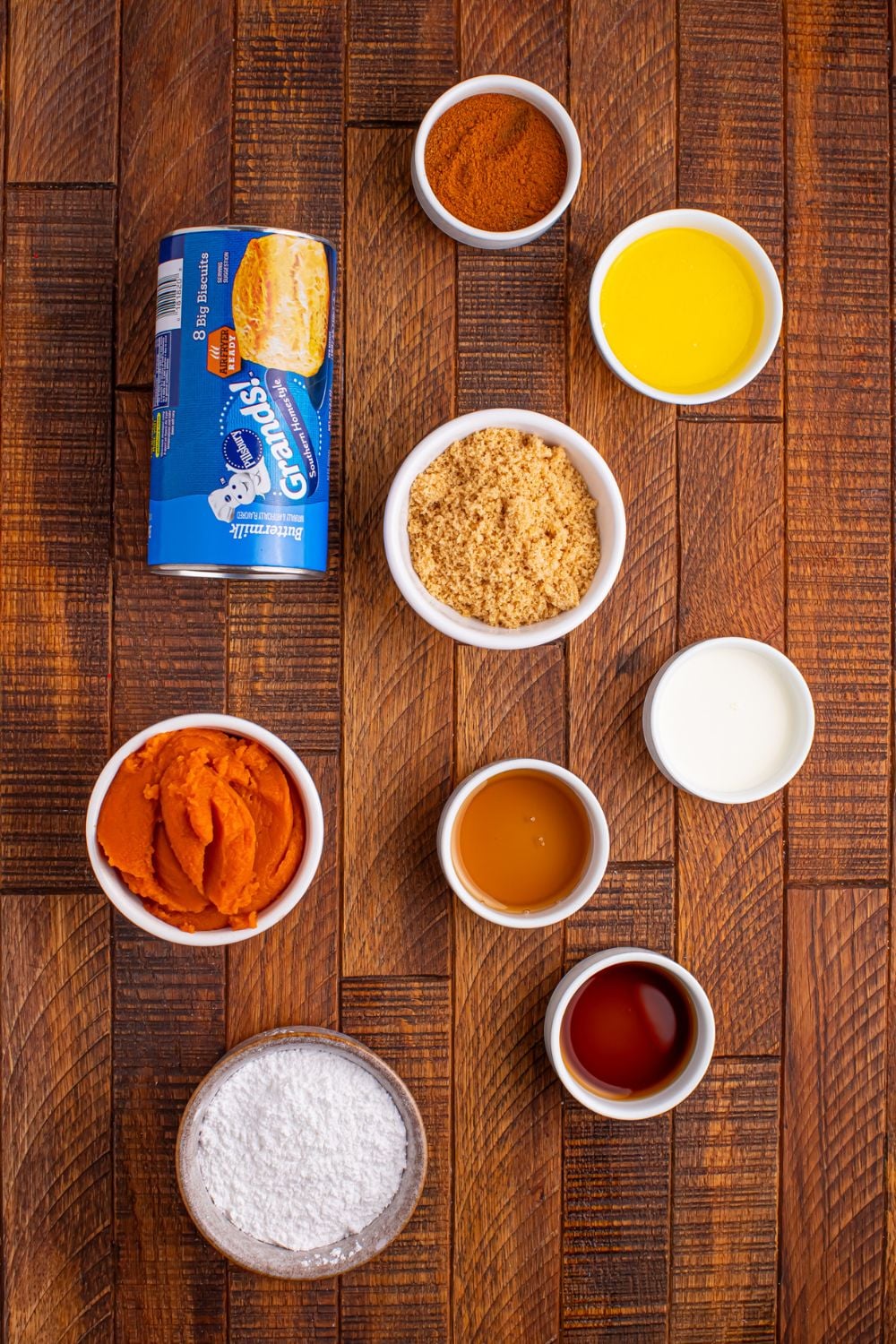 Pumpkin Pie Pull Apart Bread ingredients on table: can of biscuits, butter, brown sugar, pumpkin puree, spice, powdered sugar, and more in single serve containers.