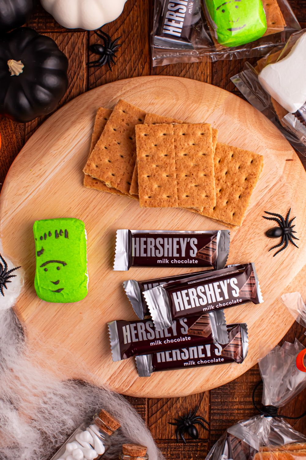 ingredients for Halloween Smores Gift Bags on table with Halloween decor items around it on table
