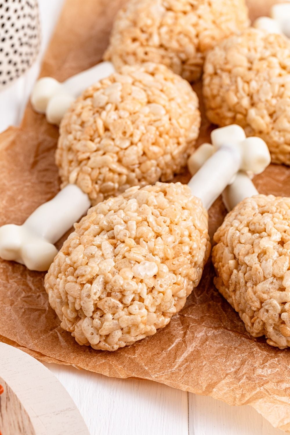 Rice Krispie Treat Turkey Legs on wax paper on table with the drumsticks stacked on top of one another