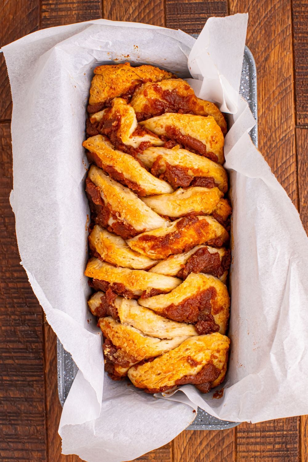 Pumpkin Pie Pull Apart Bread baked in a loaf pan with parchment paper in it 