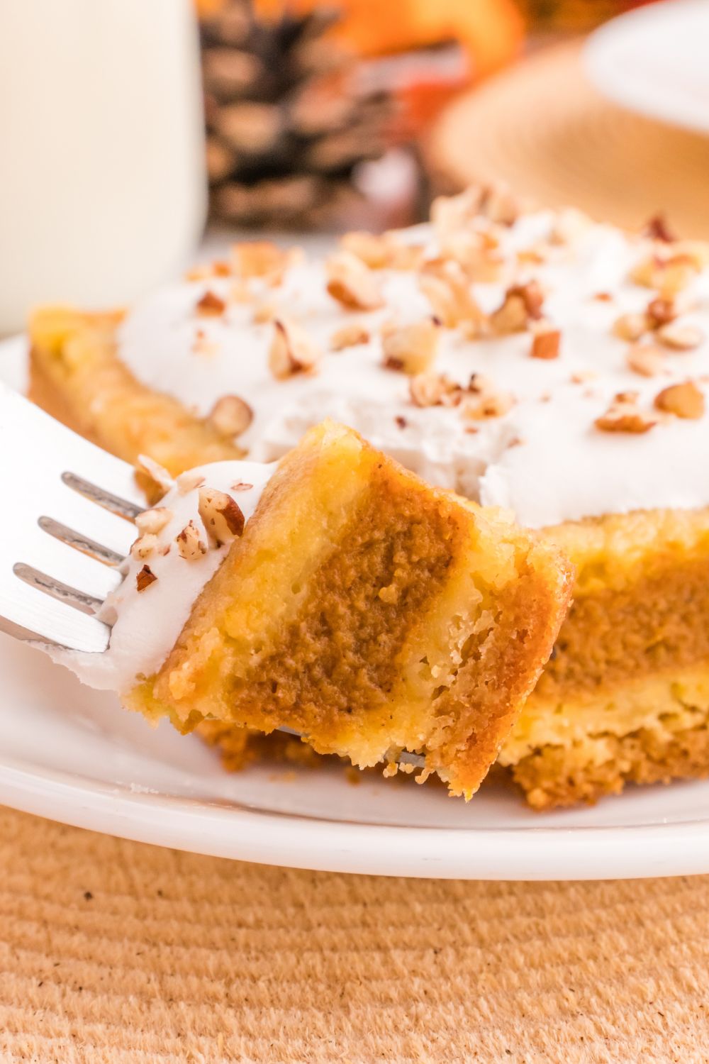 Pumpkin Pie Cake on plate with a fork with a small bite on it 