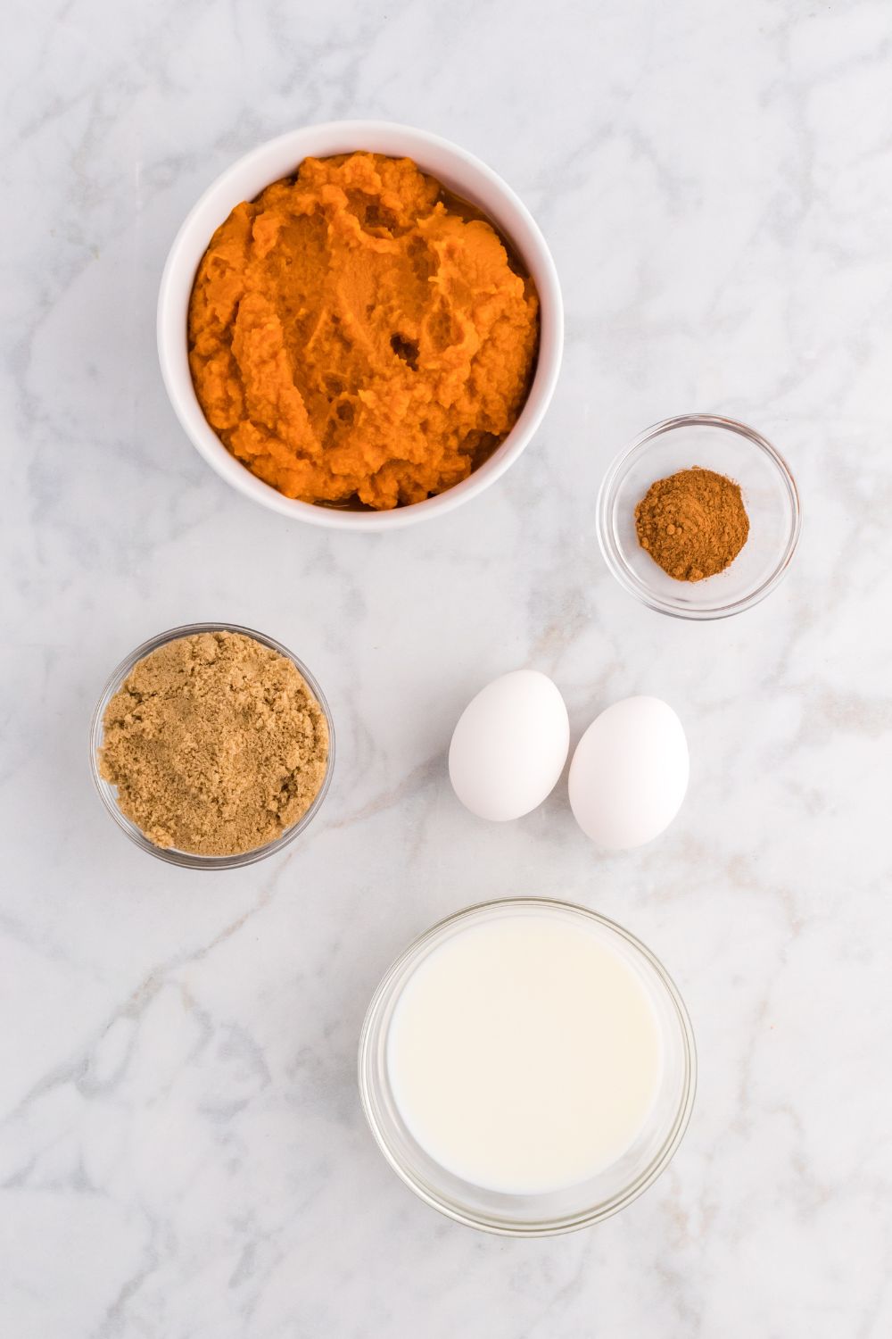 pumpkin puree, brown sugar, eggs, and other ingredients on table