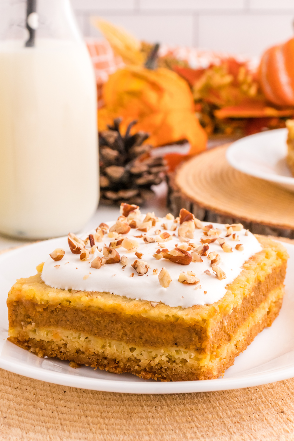 piece of Pumpkin Pie Cake is on a plate with a glass of milk to the side
