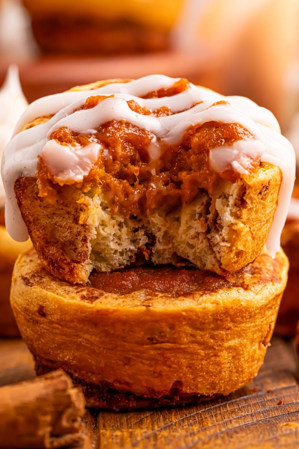 Pumpkin Pie Cinnamon Roll Cups on table that are stacked on top of one another