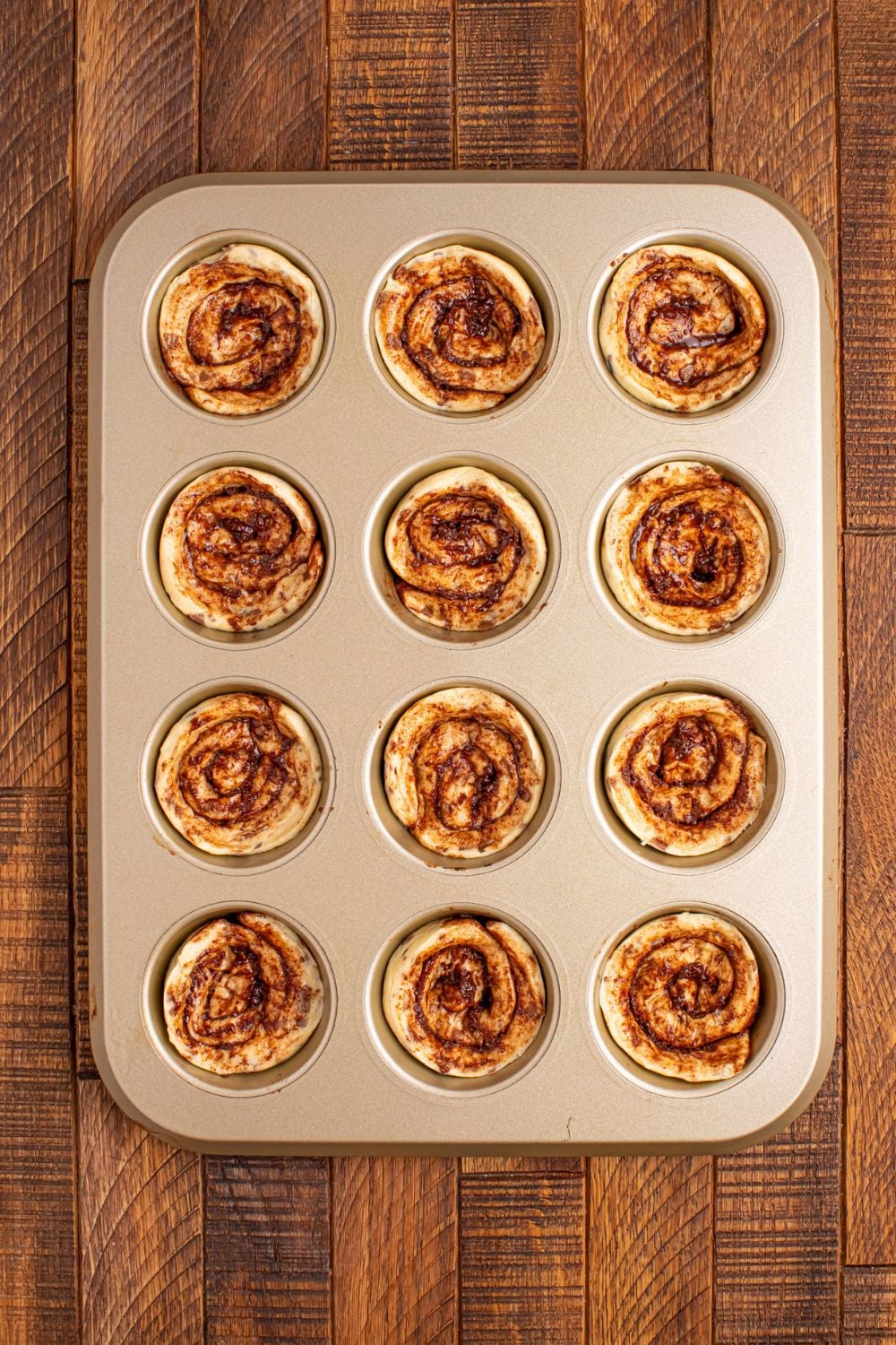 cinnamon rolls pressed into a muffin tin on table