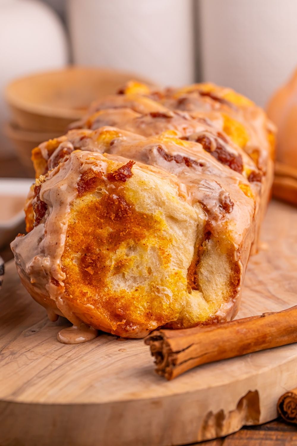 Pumpkin Pie Pull Apart Bread on table with a cinnamon stick sitting by it on the cutting board 