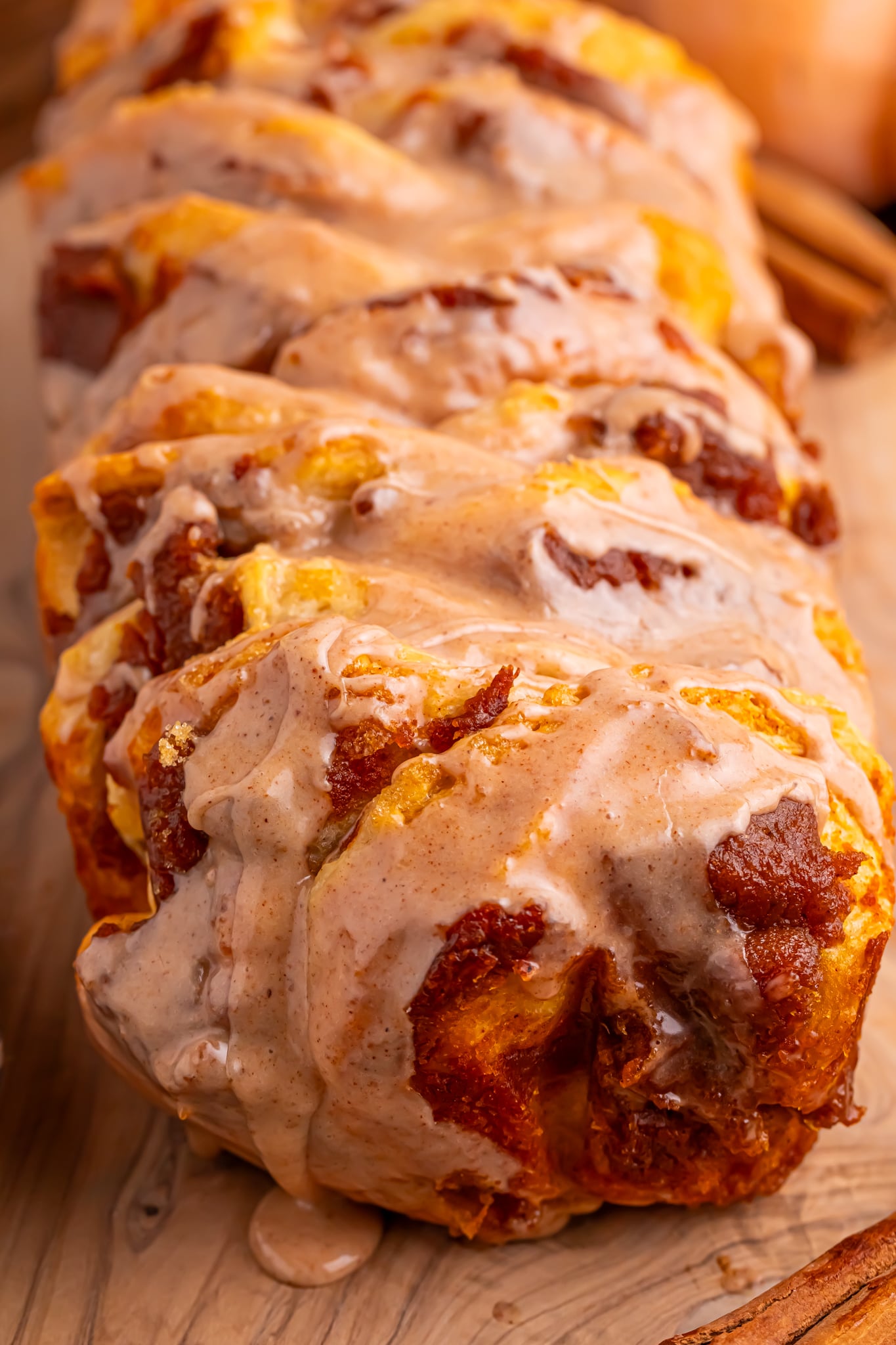 Pumpkin Pie Pull Apart Bread in a pan with a close up of the maple glaze drizzled on top 