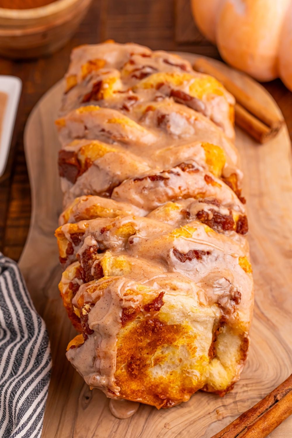Pumpkin Pie Pull Apart Bread on table with pumpkin on table and cinnamon stick on table 