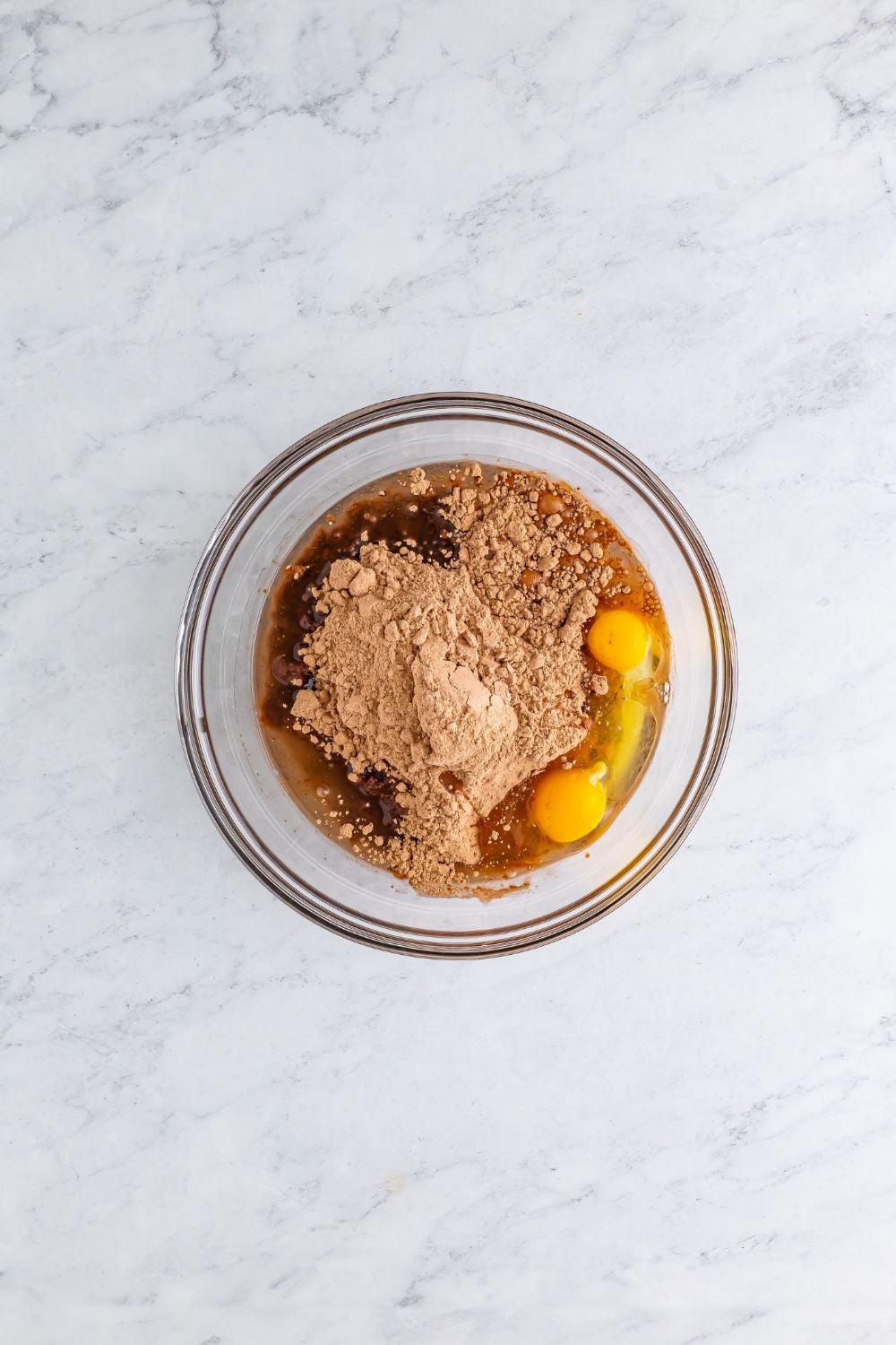brownie mix in a bowl with egg and oil in it on the sides