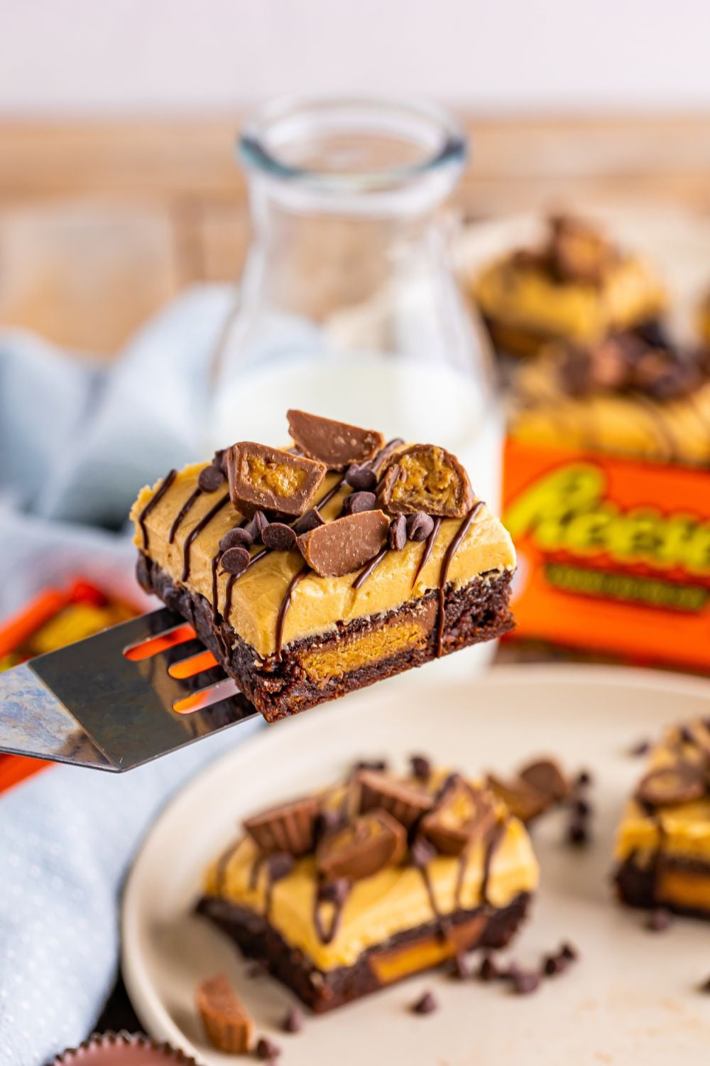 Reeses Stuffed Brownie on a spatula above table where more brownies are sitting