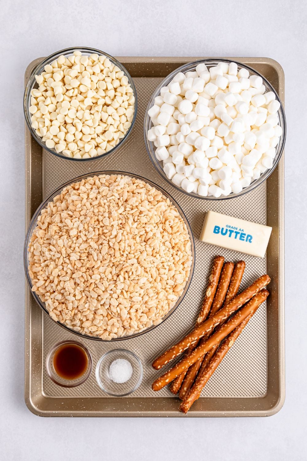 ingredients to make Rice Krispie Treat Turkey Legs on tray on table: stick of butter, pretzel rods, rice krispies, marshmallows, white chocolate, etc