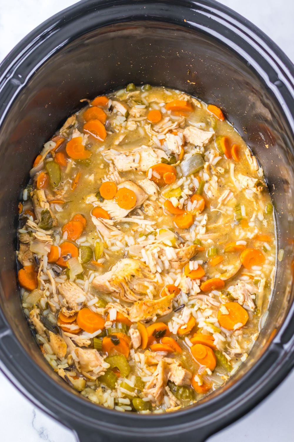 white rice turkey soup in a slow cooker sitting on counter