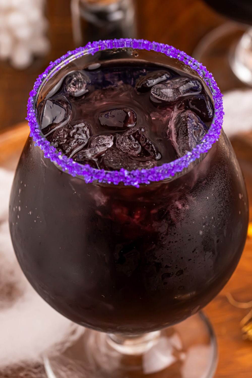 close up of Witches Brew Cocktail in a glass with a purple sugar rim