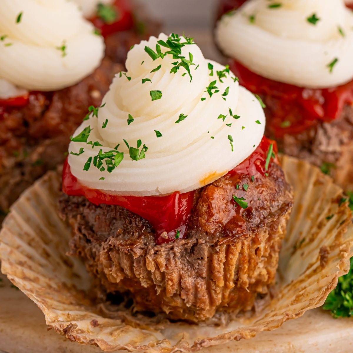 Meatloaf Cupcakes on table with the cupcake liner removed from the meatloaf