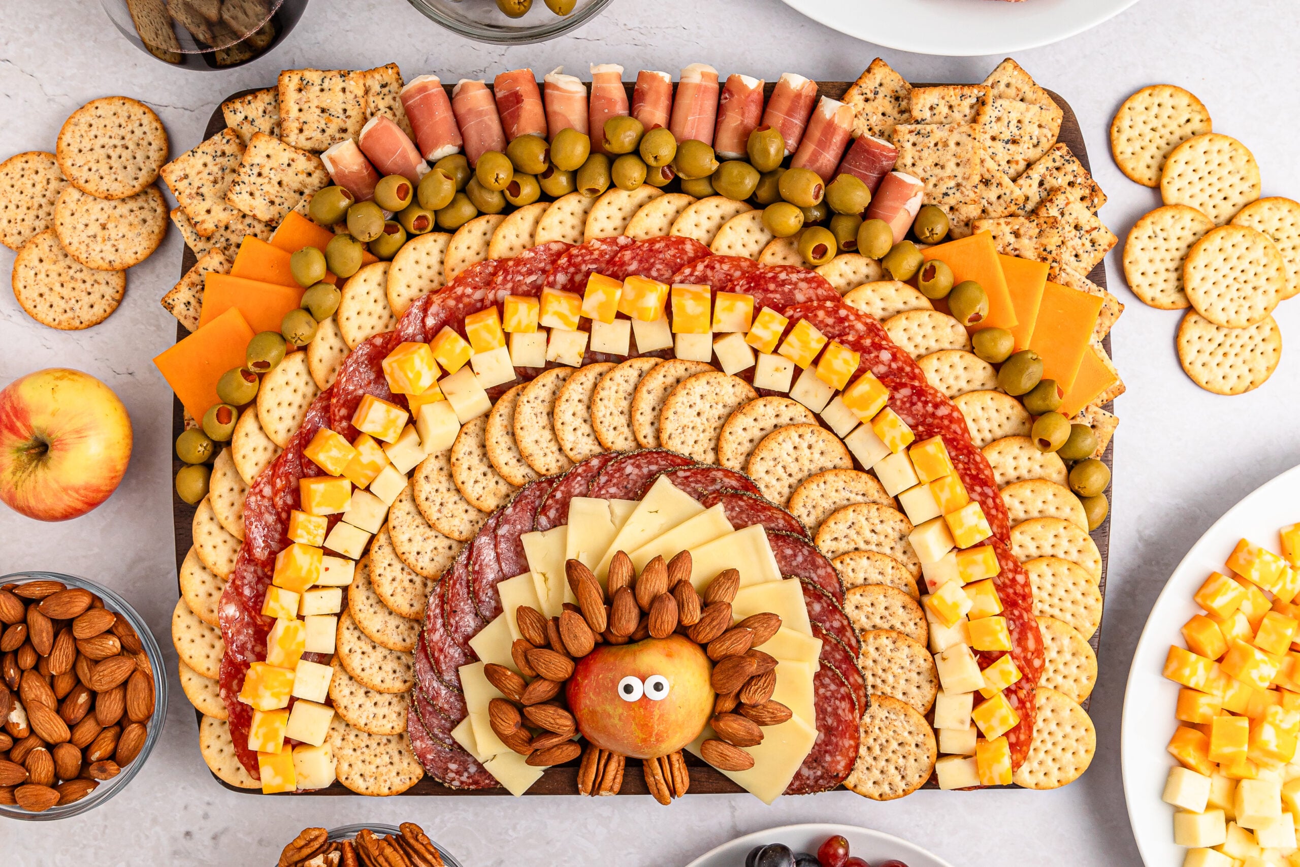 Turkey Snack Board that looks like a turkey and feathers made with meat cheese and more on a platter sitting on table