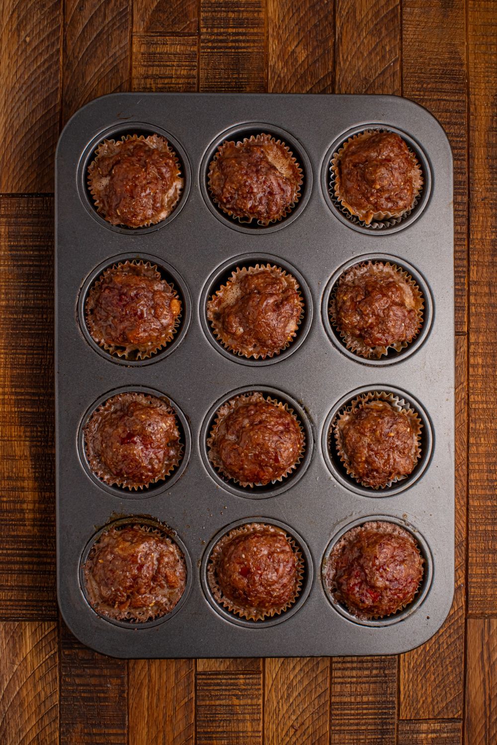 cooked meatloaf in a cupcake tray sitting on the table