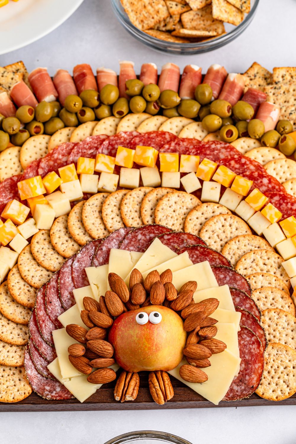 Turkey Snack Board that looks like a turkey and feathers made with meat cheese and more on a platter sitting on table