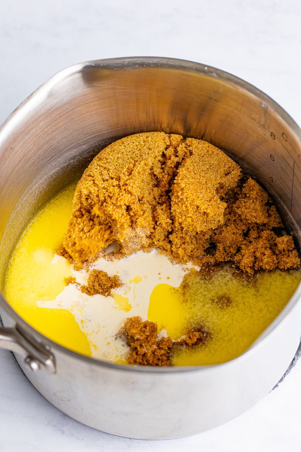 ingredients for a praline frosting in a saucepan on table