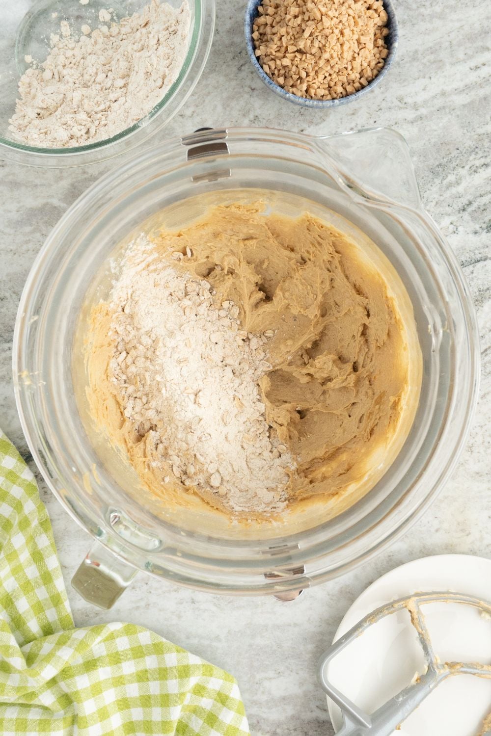 Oatmeal Toffee Cookies dough in a bowl with dry ingredients on top 