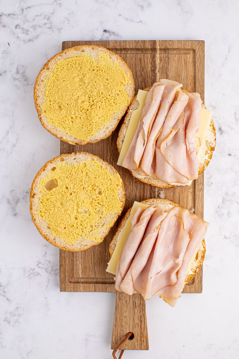 sliced rolls with turkey and cheese lunch meat on the buns 