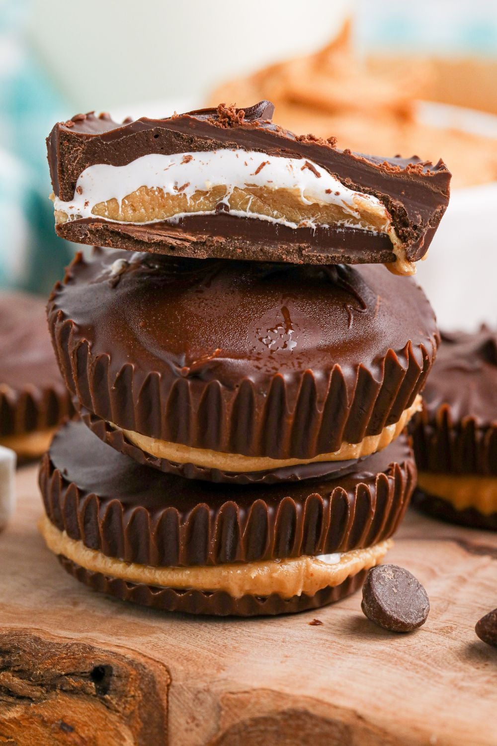 Peanut Butter Marshmallow Cups stacked on top of one another and a close up of top one cut in half to see layers of filling