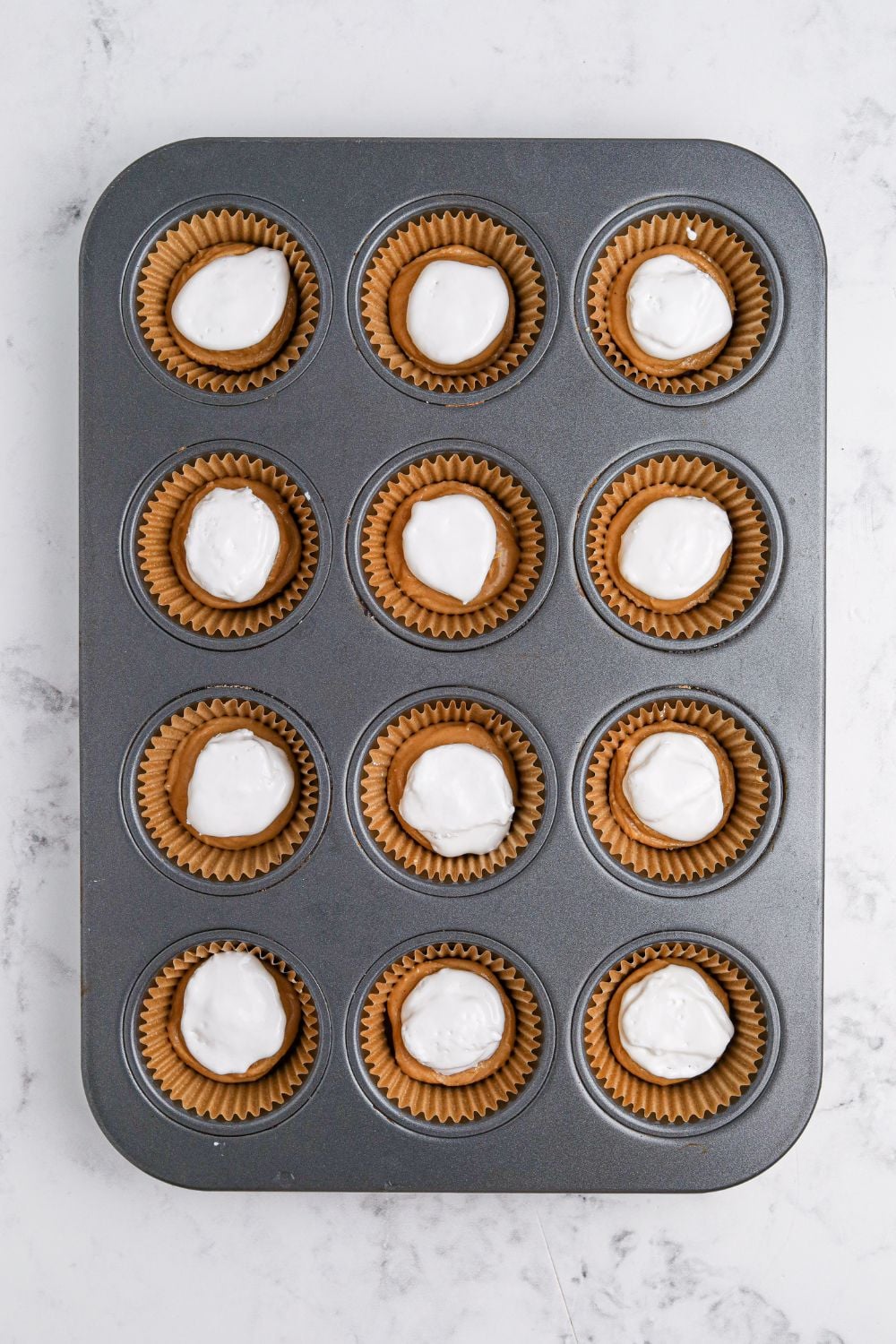marshmallow cream on top of peanut butter in muffin cups