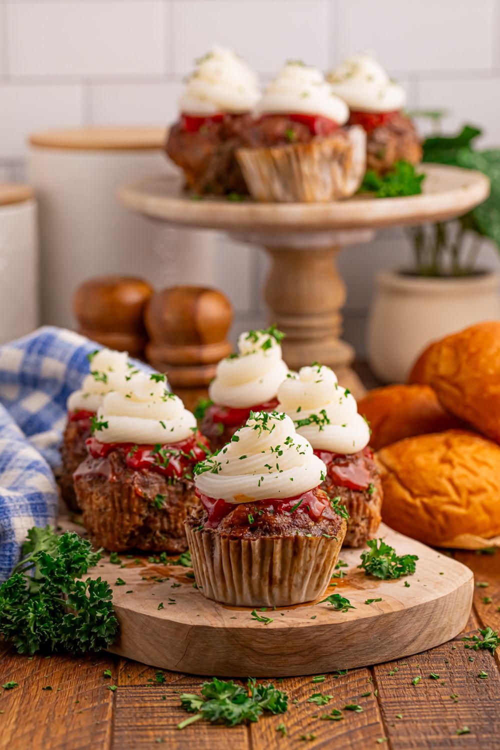 Meatloaf Cupcakes on table and on platters with parsley and dinner rolls around it on table
