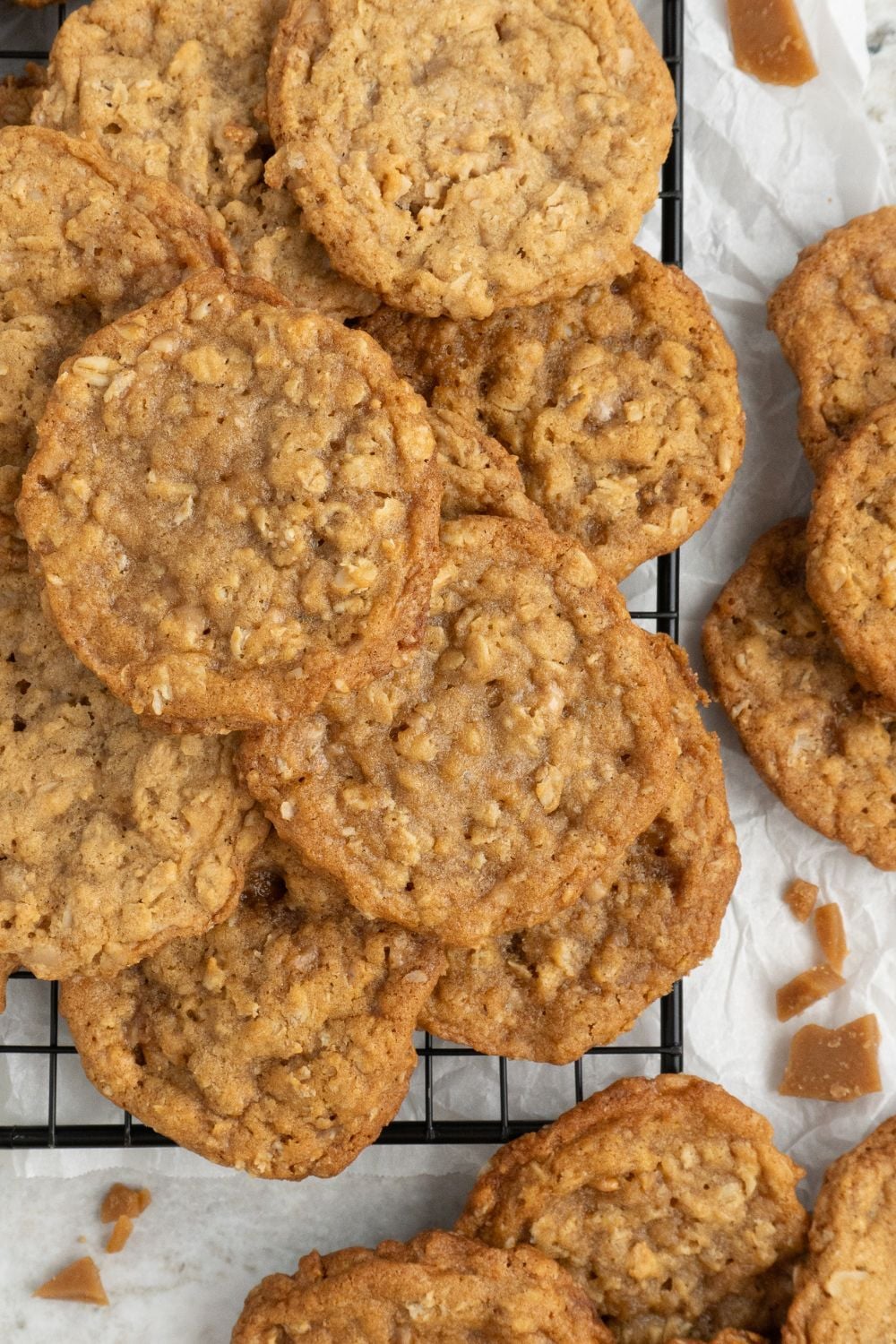 Oatmeal Toffee Cookies on a cooling tray with more cookies around the tray on table 