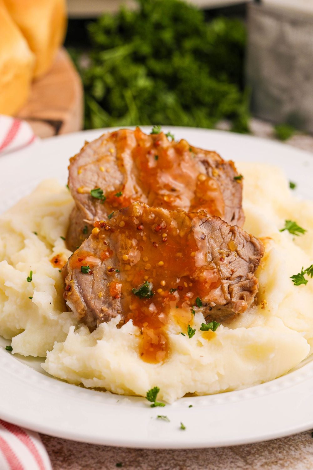 Crock Pot Apricot Pork Tenderloin on a plate with mashed potatoes under the meat