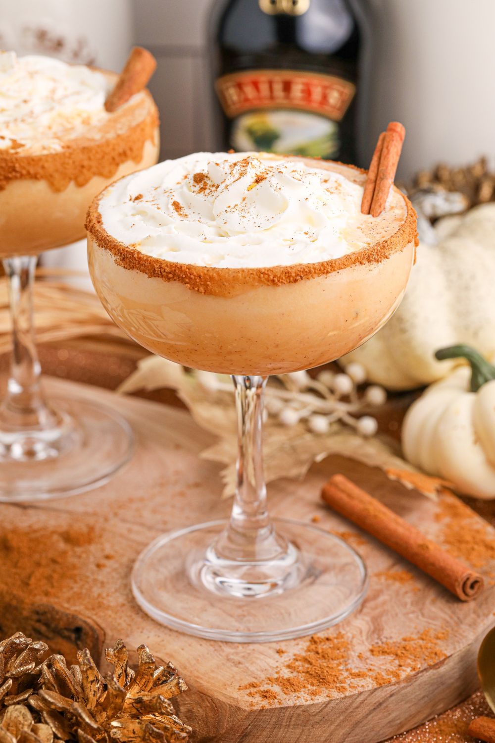 Pumpkin Pie Martinis on table with bottles of alcohol in the background