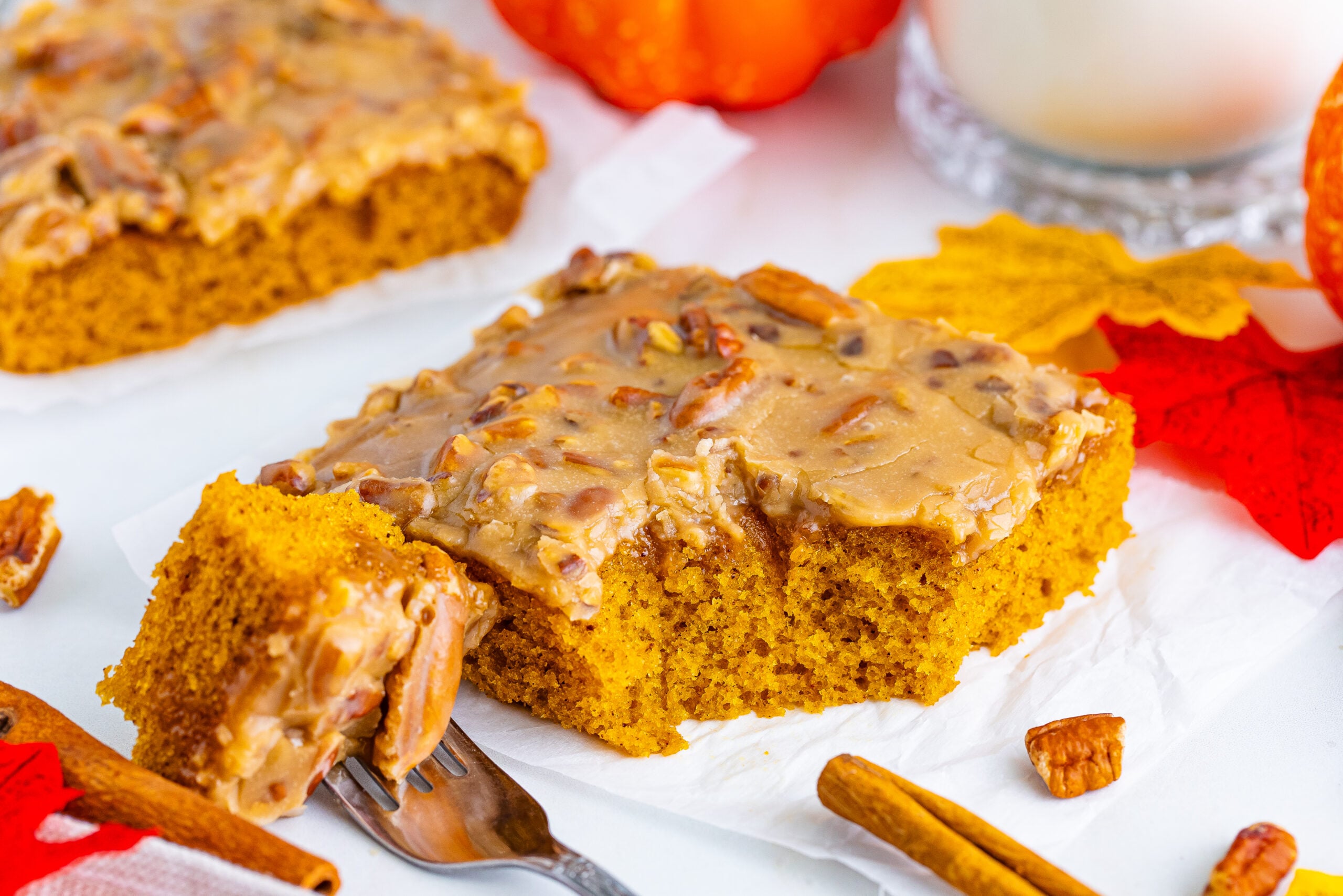 Pumpkin Snack Cake with Praline Icing on a table with a bite on a fork