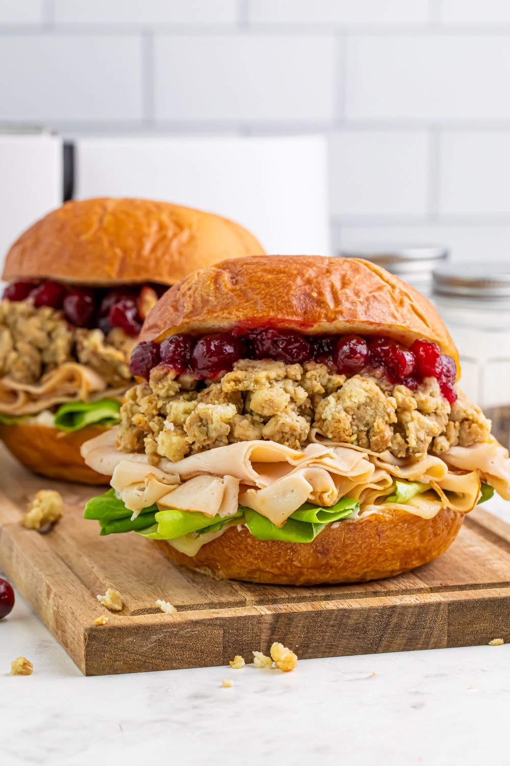 Leftover Turkey Sandwiches sitting on a cutting board on table 