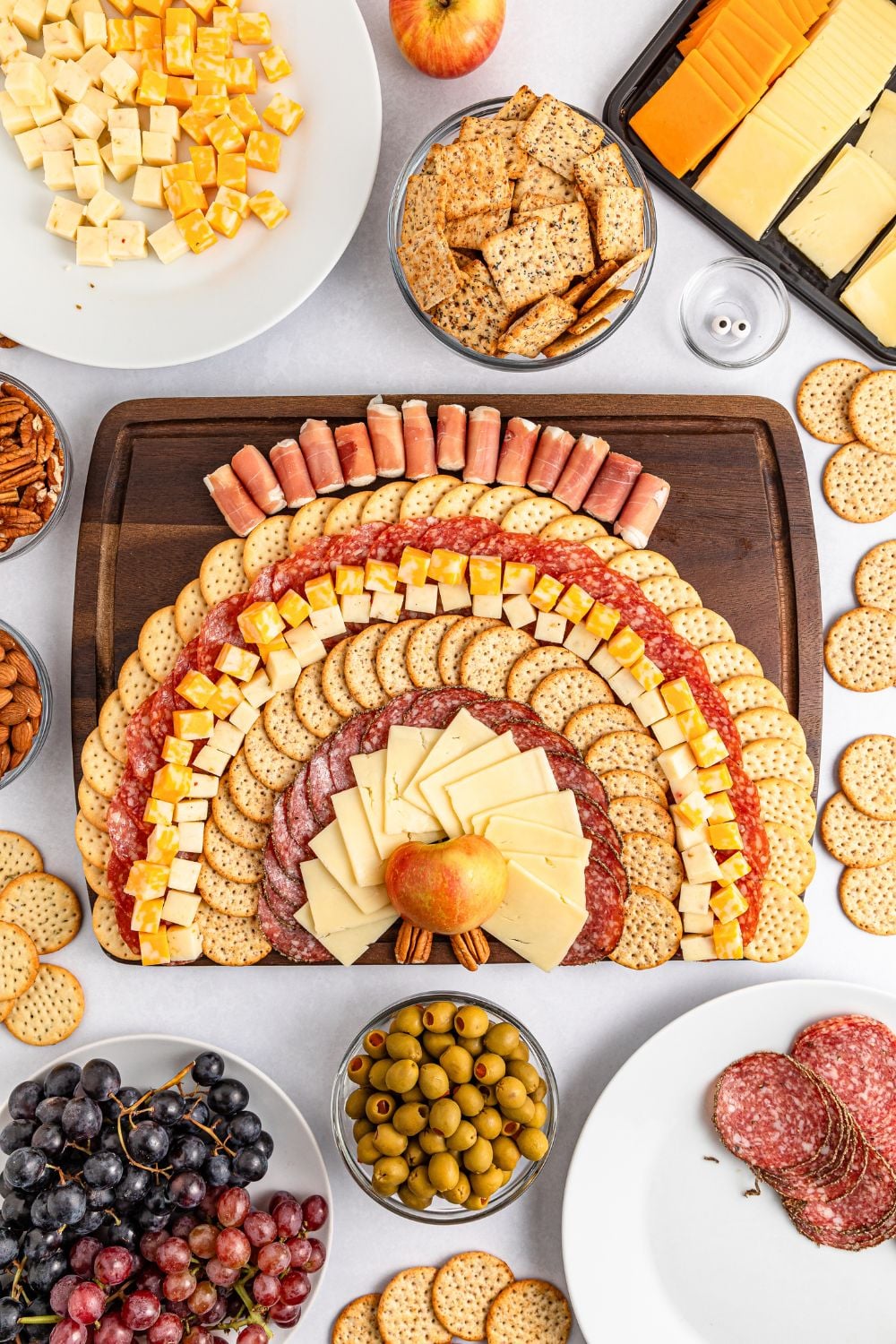 cheese and crackers being spread on board to make this Turkey Snack Board