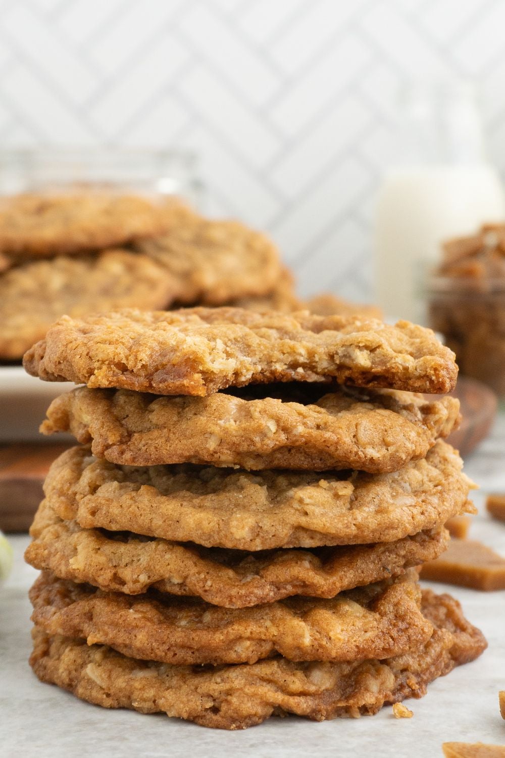 toffee chip cookies stacked on top of one another with a bite taken out of one