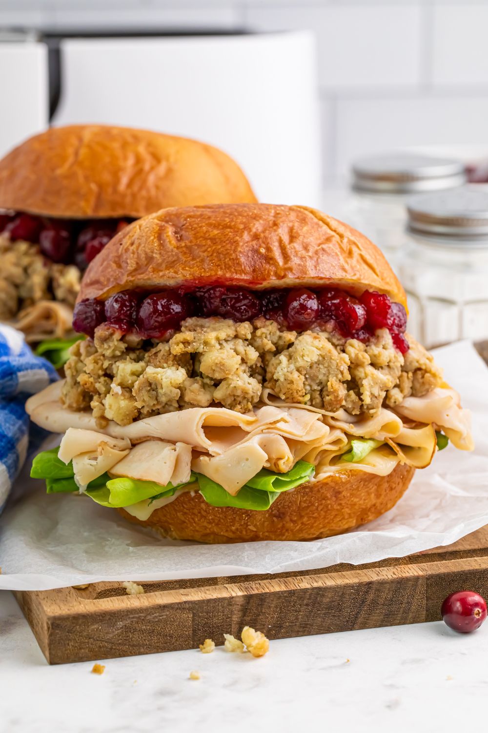 front view of turkey sandwiches stuffed with stuffing and cranberry sauce sitting on table