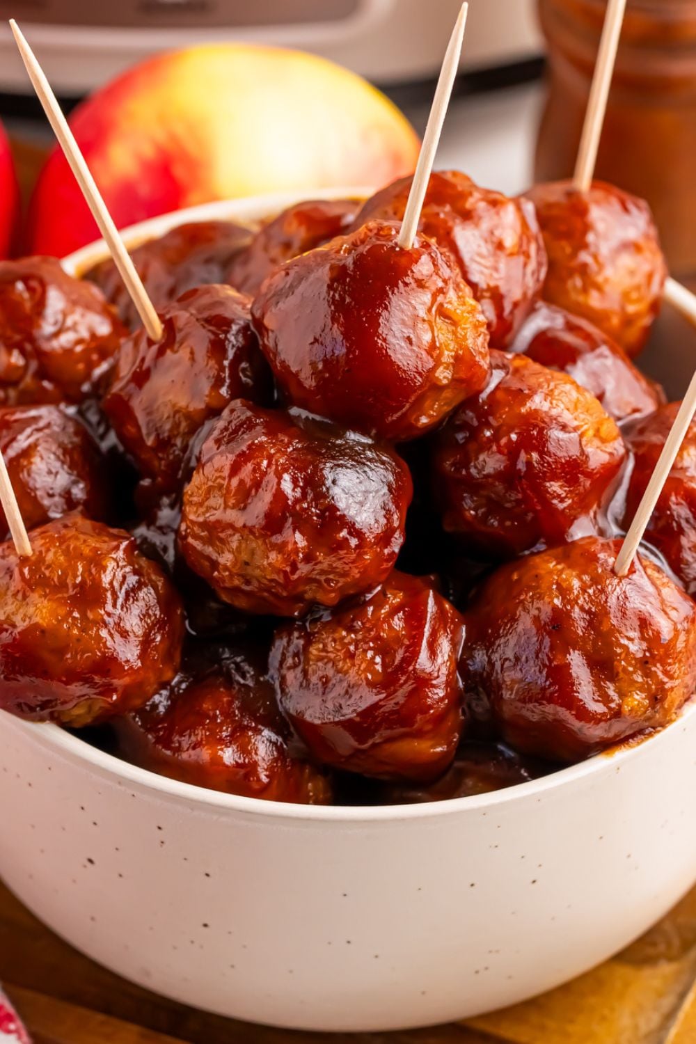 apple butter bbq meatballs in a bowl with toothpicks in them