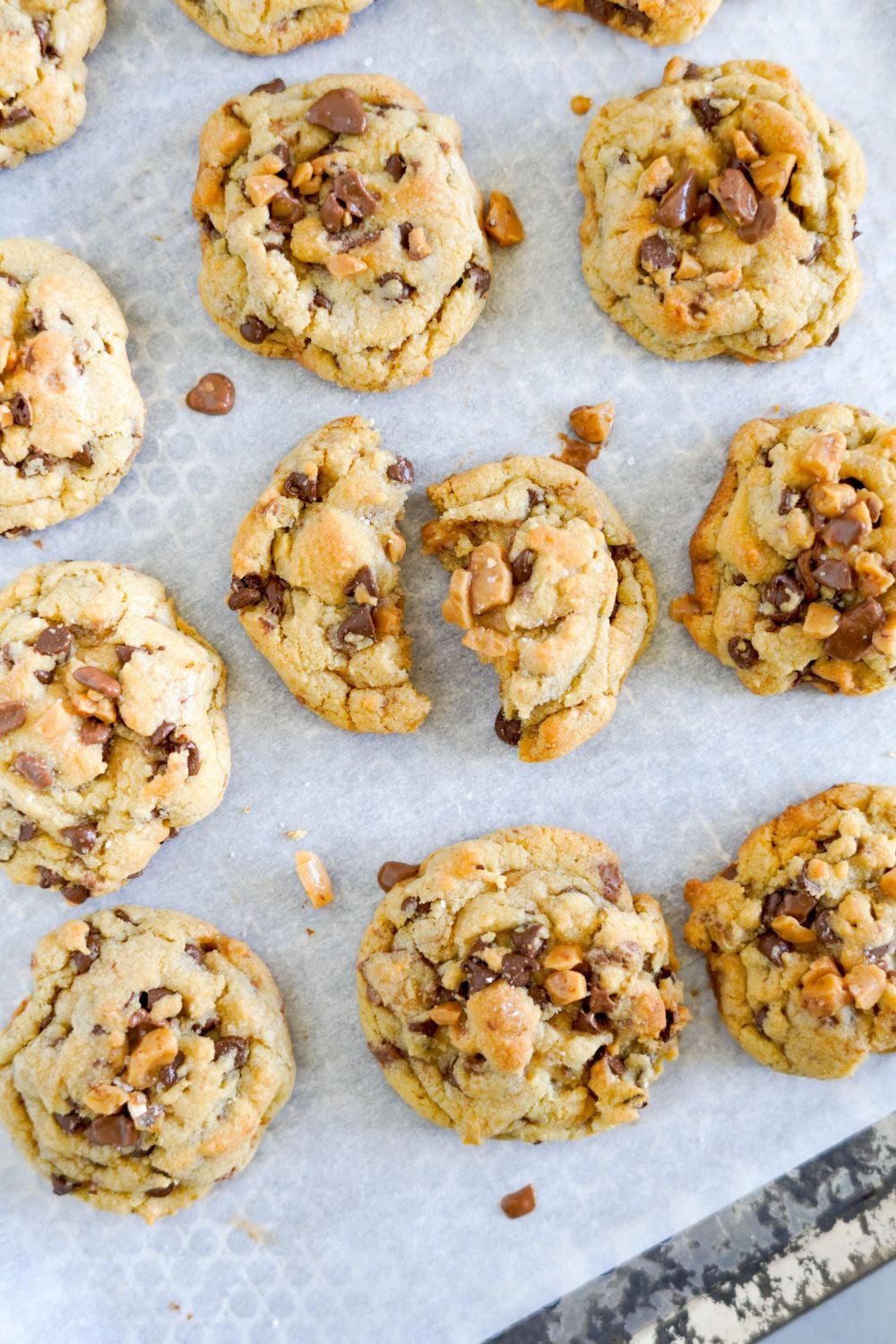Chocolate Chip Toffee Cookies on baking tray with some broken