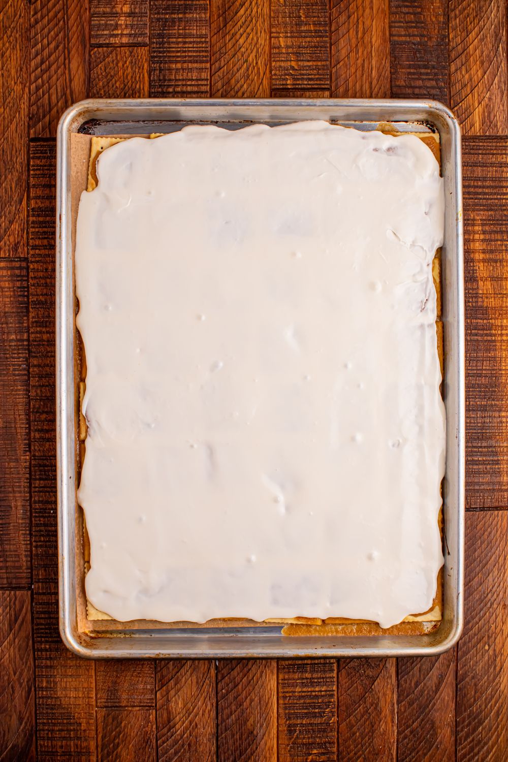 Christmas Tree Crack in a pan with the cream cheese frosting spread on top 