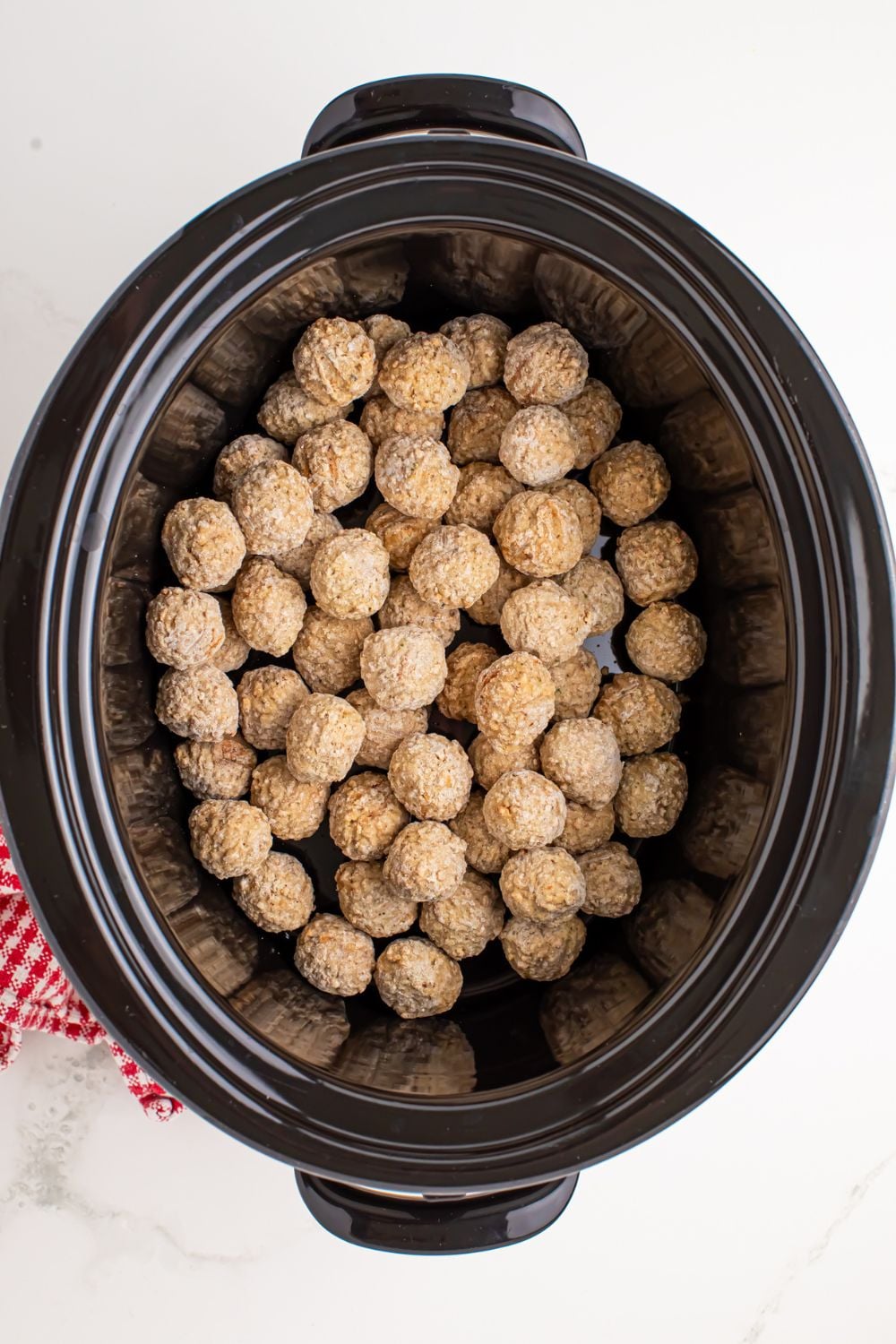 frozen meatballs in a slow cooker on table
