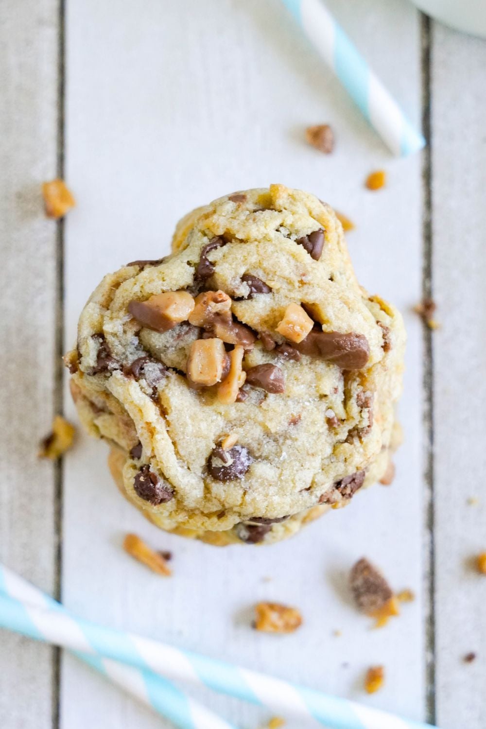 Chocolate Chip Toffee Cookies stacked on top of each other with one cookie with it bit in half