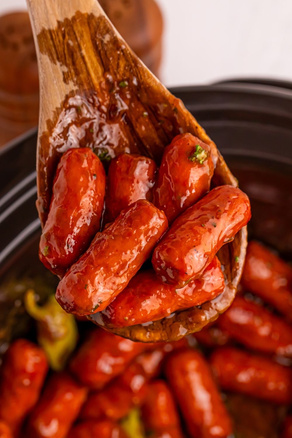 Slow Cooker Mississippi Lil Smokies in slow cooker with a wooden spoon with some smokies on it 
