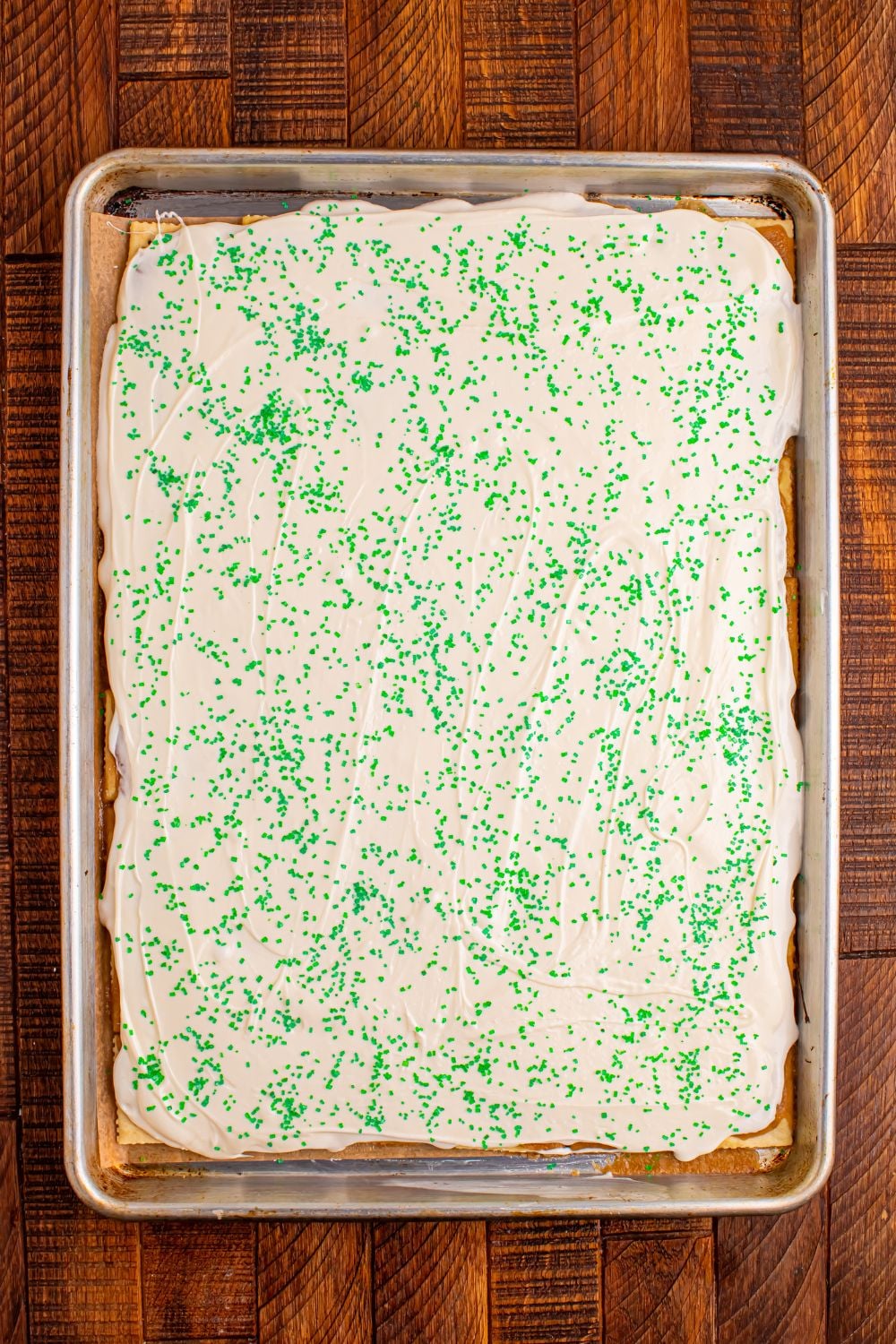 overhead view of Christmas Tree Crack in a sheet pan with green sprinkles on top 