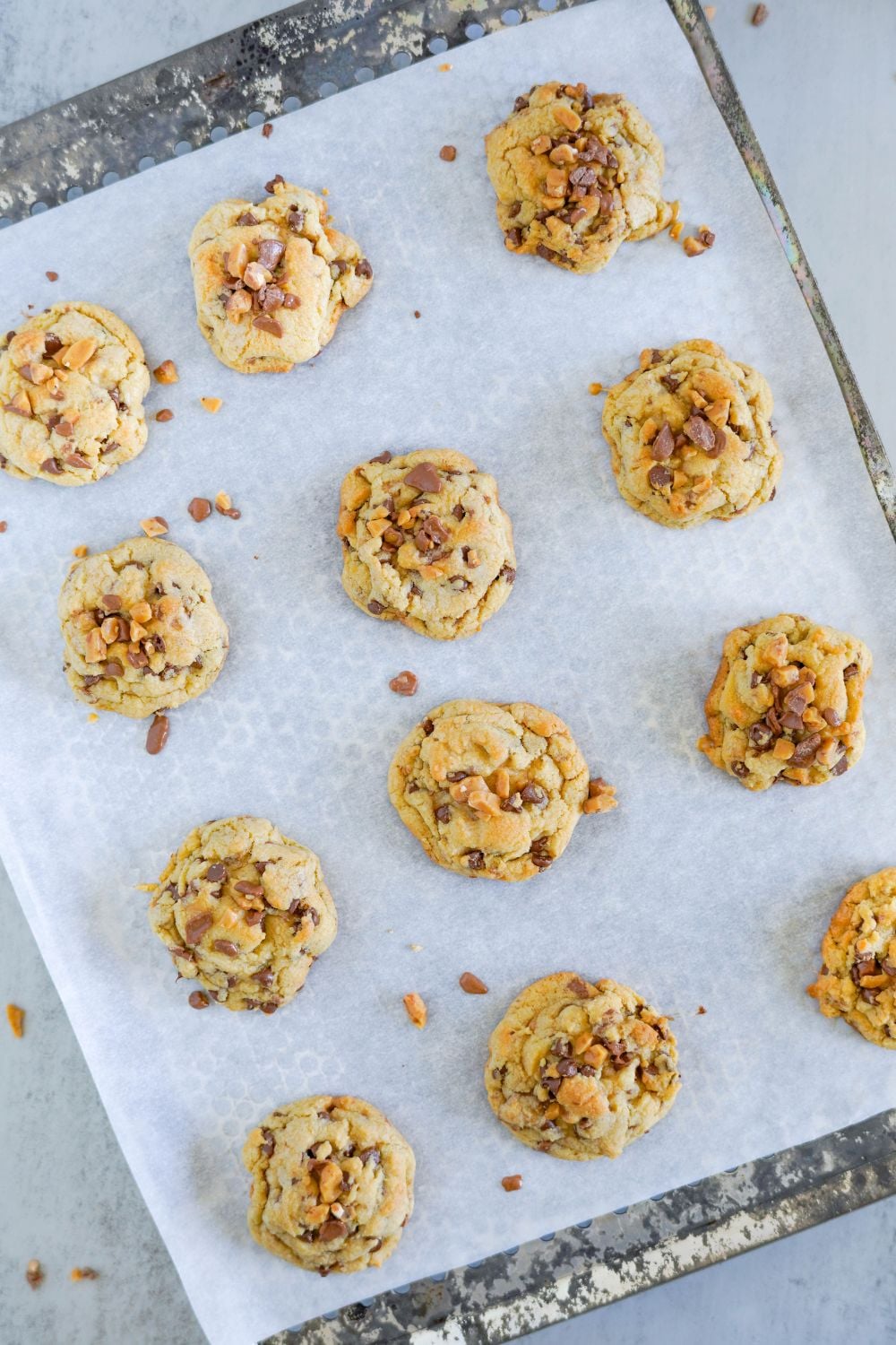 baked Chocolate Chip Toffee Cookies on a baking sheet on table