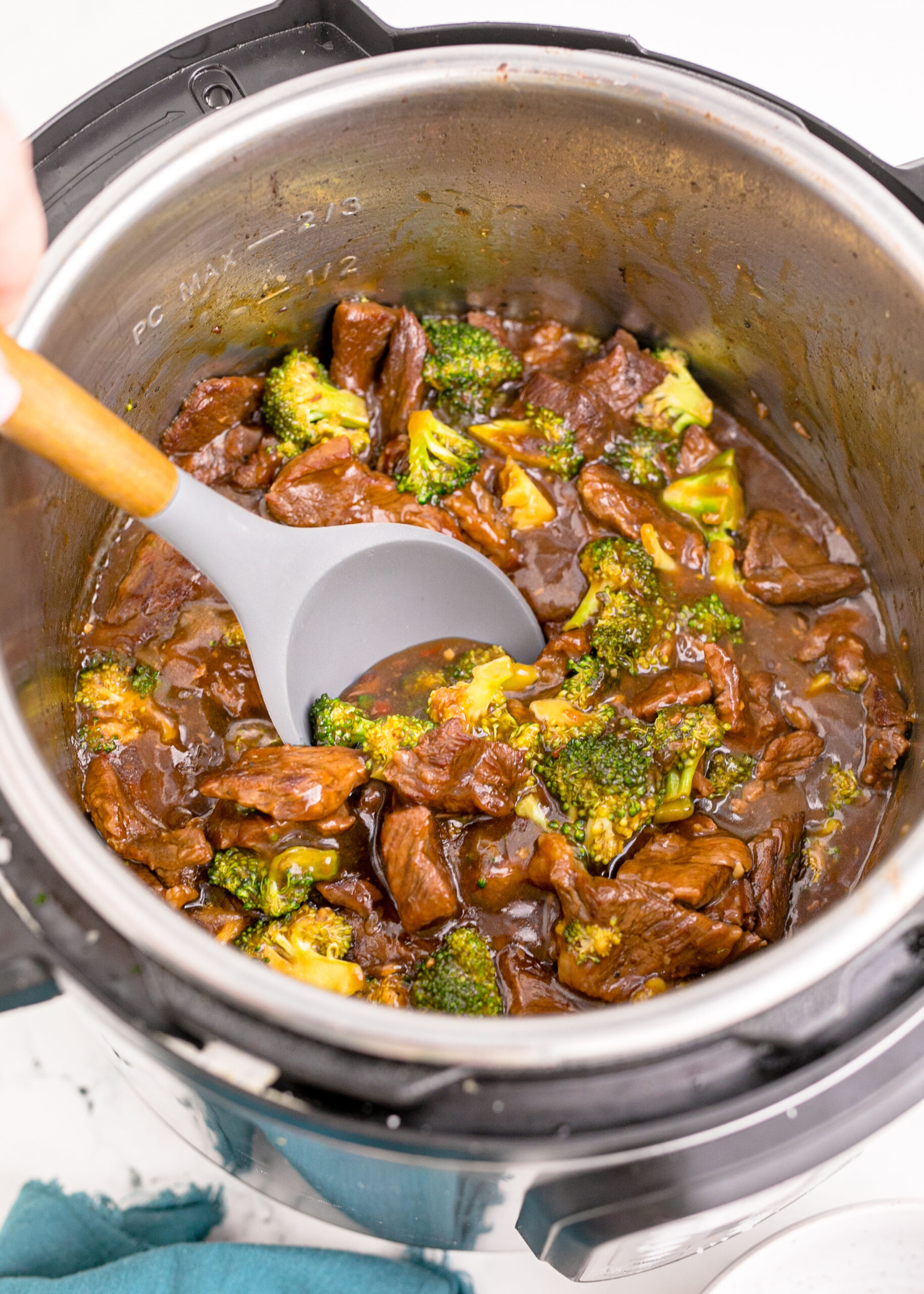 Instantpot Beef & Broccoli in the instantpot showing how delicious it looks with a spoon lifting some