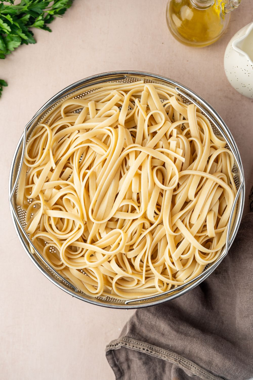 fettuccine pasta in a strainer sitting on counter 