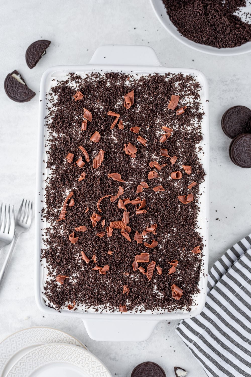 Chocolate Oreo Lush in casserole pan sitting on counter with cookies around it 