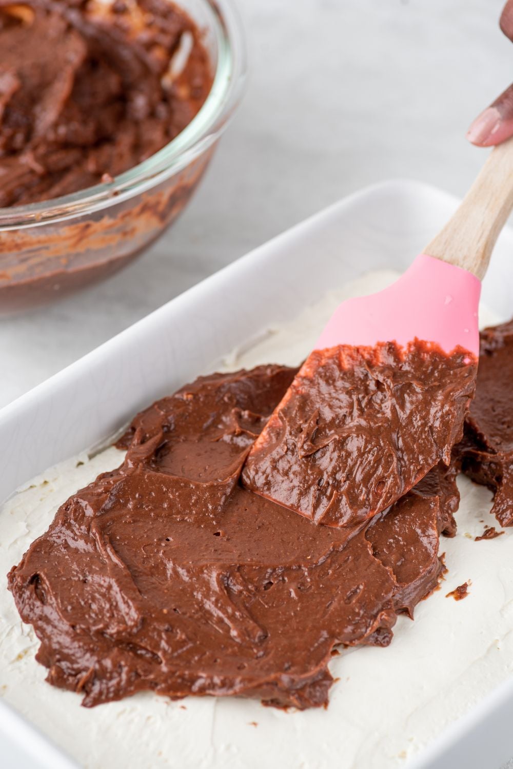 chocolate pudding spreading over the whipped cream layer 