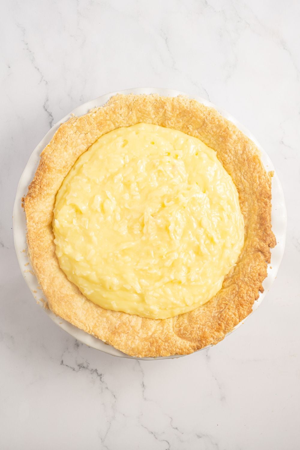 Coconut Meringue Pie filling in a pie crust on table 